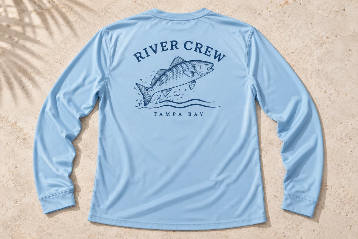 Mockup of a light blue River Crew long sleeve shirt with a speckled trout and Tampa Bay lettering.