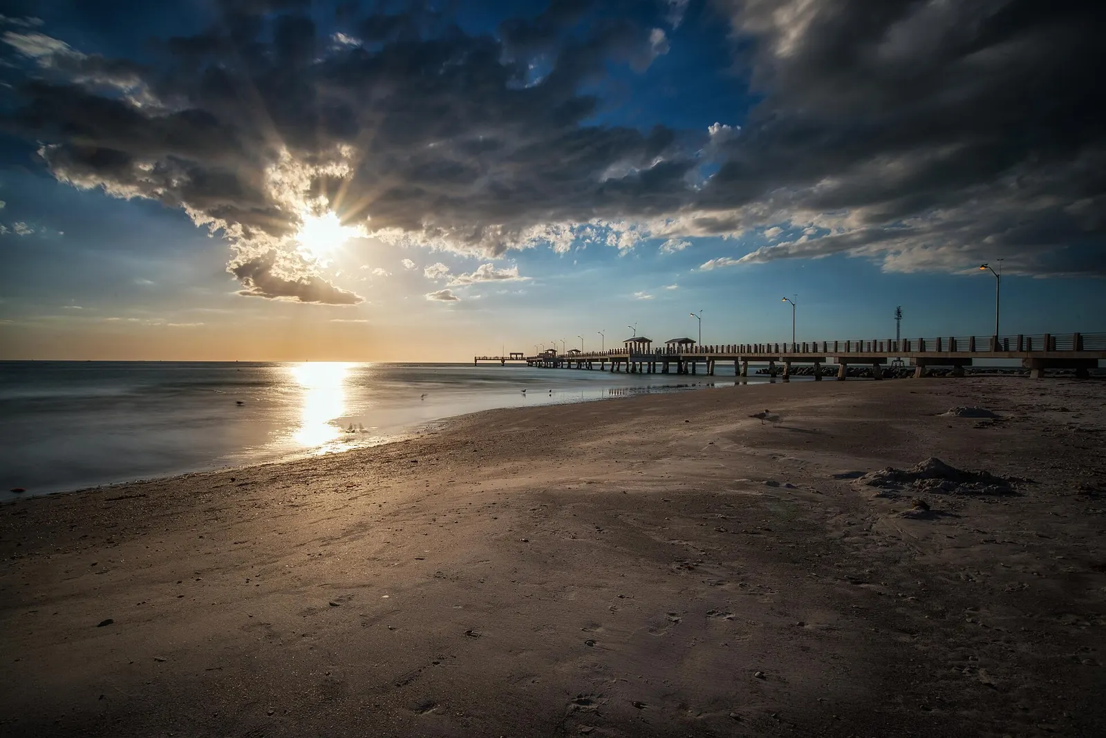 A fishing pier at Fort De Soto Park stretching into the water at sunset